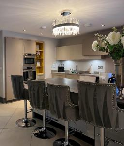 a kitchen with a table and chairs and a vase with flowers at Luxury Durham Home, Sleeps up to 12, Free Parking in Durham