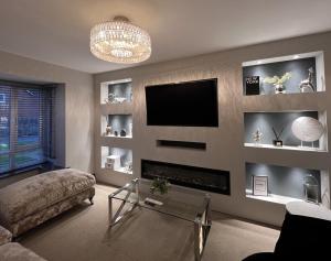 a living room with a fireplace and a tv at Luxury Durham Home, Sleeps up to 12, Free Parking in Durham