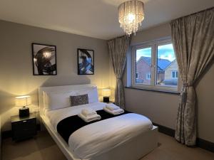 a bedroom with a white bed with a window at Luxury Durham Home, Sleeps up to 12, Free Parking in Durham