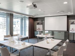 a conference room with tables and a projector screen at Mercure Blankenberge in Blankenberge +73 photos