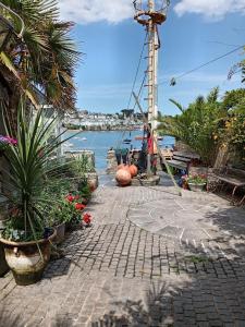 a walkway next to a body of water with plants at Polmarine in Polruan
