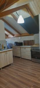 a kitchen with wooden cabinets and a ceiling with a light at Captain in Ureki