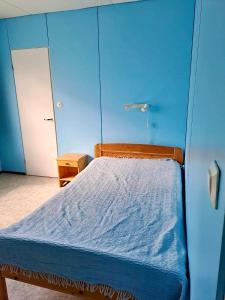 a bedroom with a bed with a blue wall at Erillinen talo Kiuru in Nilsiä