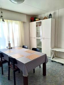 a dining room table with chairs and a white refrigerator at Erillinen talo Kiuru in Nilsiä