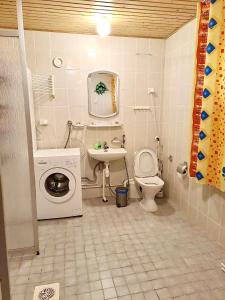 a bathroom with a washing machine and a sink at Erillinen talo Kiuru in Nilsiä +11 photos