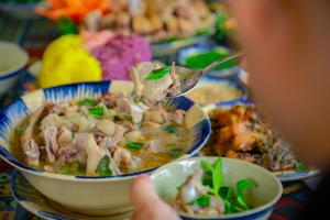 a person eating a bowl of soup with a spoon at Moon Luxury Hotel in Hanoi +15 photos