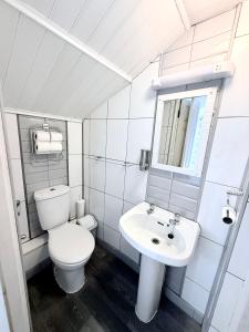 a white bathroom with a toilet and a sink at Cherish Lewis Hotel- Hull Road, Blackpool Central in Blackpool