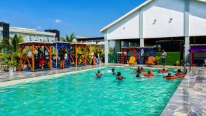 a group of people in a swimming pool at Westside Beach Resort & Hotel in Mopo Akinlade