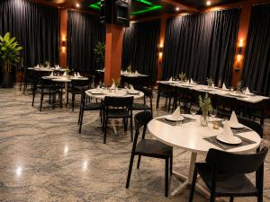 a dining room with tables and chairs and a tv at Westside Beach Resort & Hotel in Mopo Akinlade