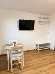 a room with a table and a tv on a wall at Sleep & Go Höchst in Höchst +10 photos