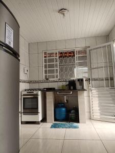 a kitchen with white appliances in a room at Casa com churrasqueira – Próx. Shopping Comércios in Várzea Paulista