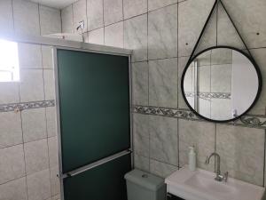 a bathroom with a shower and a sink and a mirror at Casa com churrasqueira – Próx. Shopping Comércios in Várzea Paulista