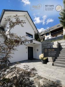 a white house with a staircase and a building at Villa Number 8 in Feldberg +16 photos