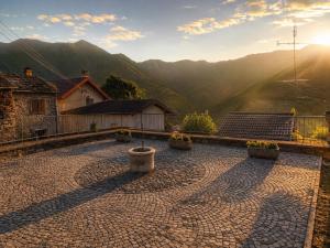 a stone patio with a view of a mountain at La Baita Delle Due Valli in Maccagno Superiore