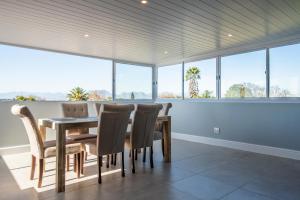 a dining room with a table and chairs and windows at Culem View's in Eversdal +4 photos