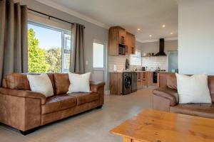 a living room with two couches and a kitchen at Culem View's in Eversdal