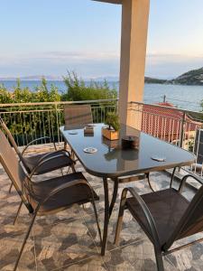 a table and chairs on a patio with a view of the ocean at Giannis Philoxenia in Kakí Vígla