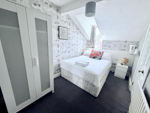 a small bedroom with a white bed in a attic at Cherish Lewis Hotel- Hull Road, Blackpool Central in Blackpool +32 photos