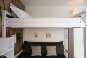a bedroom with two bunk beds and a couch at Lætitia Cottage Apartment in Aversa