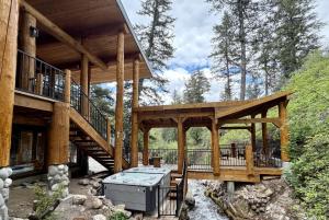 a large wooden cabin with a deck and stairs at Log Cabin On The Stream Sundance, Utah in Sundance