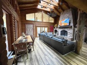 a living room with a table and a fireplace at Log Cabin On The Stream Sundance, Utah in Sundance