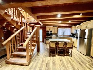 a kitchen with a table and a kitchen with a staircase at Log Cabin On The Stream Sundance, Utah in Sundance