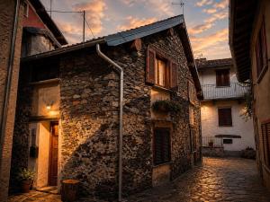 an old stone building with a street light next to it at La Baita Delle Due Valli in Maccagno Superiore +2 photos