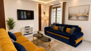 a living room with a blue couch and a table at Greenfield Villa D- Diani in Diani Beach