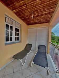 a porch with two beds on a balcony at Le paradis créole in Sainte-Luce