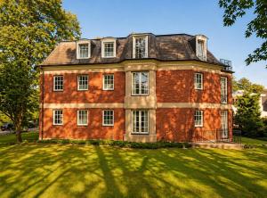 an old brick house on a grassy field at Les Jardins Blankenese in Hamburg