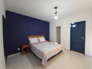 a bedroom with a bed and a blue wall at Anexo da Paz Tucuns Búzios in Búzios +38 photos