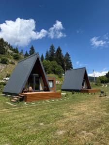 two lodges in a field with grass at Bjelašnica Frame in Bjelašnica