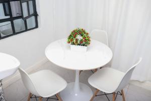 a white table with white chairs and a plant on it at HOBRA HOMEs -Naivasha B in Naivasha