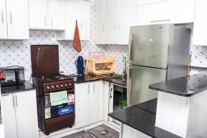 a kitchen with white cabinets and a stainless steel refrigerator at HOBRA HOMEs -Naivasha B in Naivasha