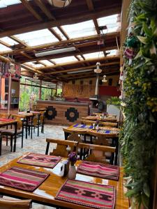 a restaurant with wooden tables and chairs and a stove at Hotel Tambo del Valle in Urubamba