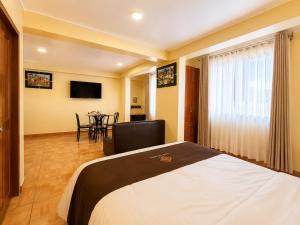 a hotel room with a bed and a dining room at Hotel Tambo del Valle in Urubamba