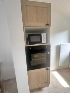 a kitchen with a microwave and a refrigerator at Le petit rêve in Fours