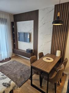 a dining room with a wooden table and chairs at Zlatibor 1 Balkan Square in Zlatibor