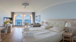 a bedroom with a large bed with a view of the ocean at Hotel Kvarner Palace in Crikvenica +102 photos