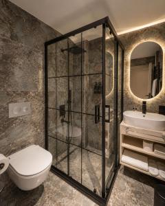 a bathroom with a shower and a toilet and a sink at Nevv City Hotel in Istanbul