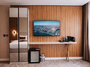 a bedroom with a bed and a tv on a wall at Nevv City Hotel in Istanbul