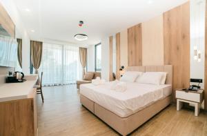 a bedroom with a large white bed and a kitchen at Velmare Inn in Ulcinj