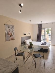 a bedroom with a bed and a glass table and chairs at Summer's Hotel Apartments in Ayia Napa
