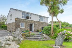 a stone house with a palm tree in front of it at 2 Bed in Cashel oc-i223 in Moyrus
