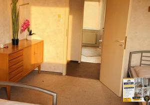 a bedroom with a bed and a dresser and a room with a bathroom at Harzer Monteurs-Lounge Domschatz-Nähe in Halberstadt +5 photos