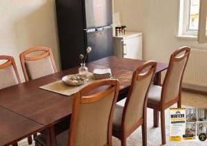 a kitchen with a wooden table with chairs and a refrigerator at Harzer Monteurs-Lounge Domschatz-Nähe in Halberstadt