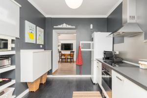 a kitchen with white cabinets and a dining room at La Fuente 33 in Castro-Urdiales