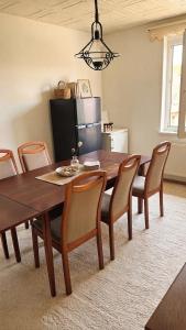 a dining room table with chairs and a refrigerator at Harzer Monteurs-Lounge Domschatz-Nähe in Halberstadt