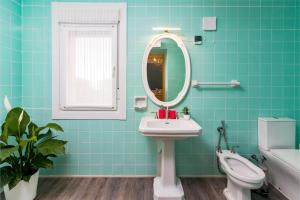 a bathroom with a sink and a mirror and a toilet at La Fuente 33 in Castro-Urdiales +7 photos