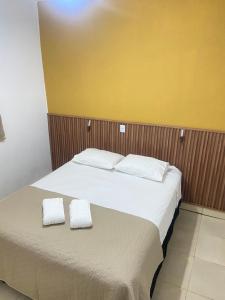 a bedroom with a bed with two white towels on it at Recanto da Caluninha in Esmeraldas +47 photos